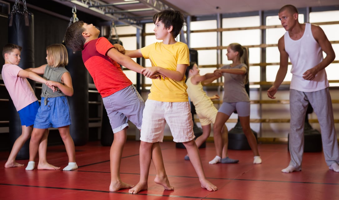 Kids in pair exercising self-defense movements